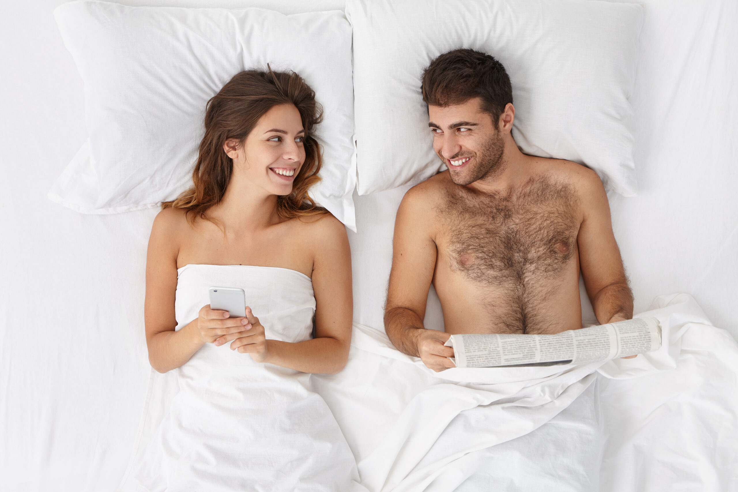 Pareja en la cama usando juguetes sexuales